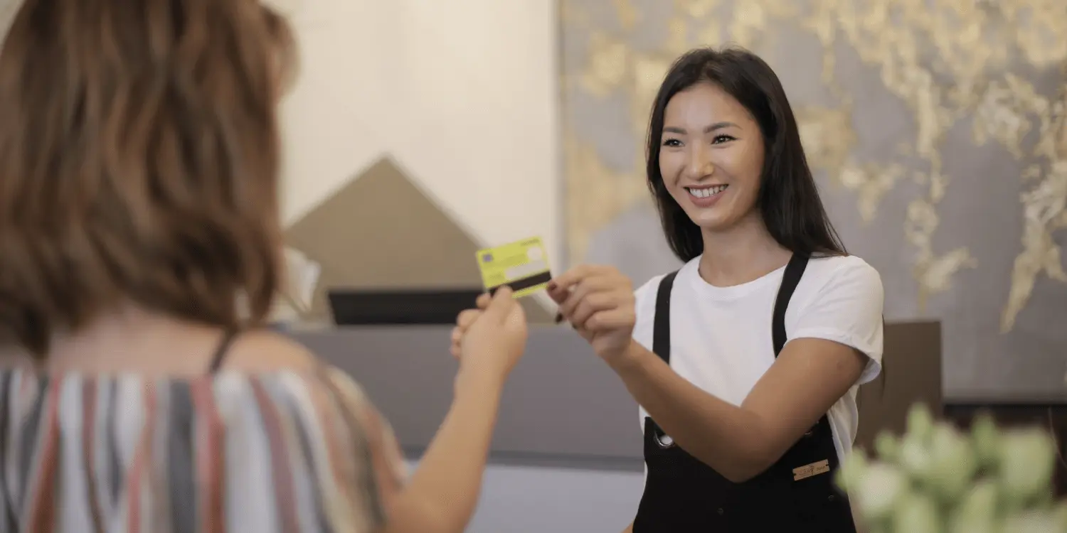 A person holding a store credit card the just opened in the store. 