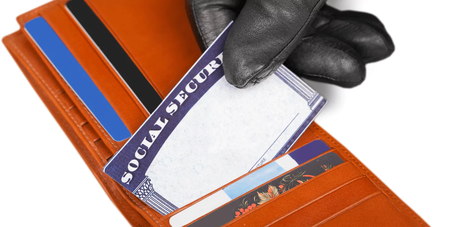 Gloved hand stealing a Social Security card from a wallet. Emphasizing the importance of protecting personal information against identity theft, crucial for financial security.
