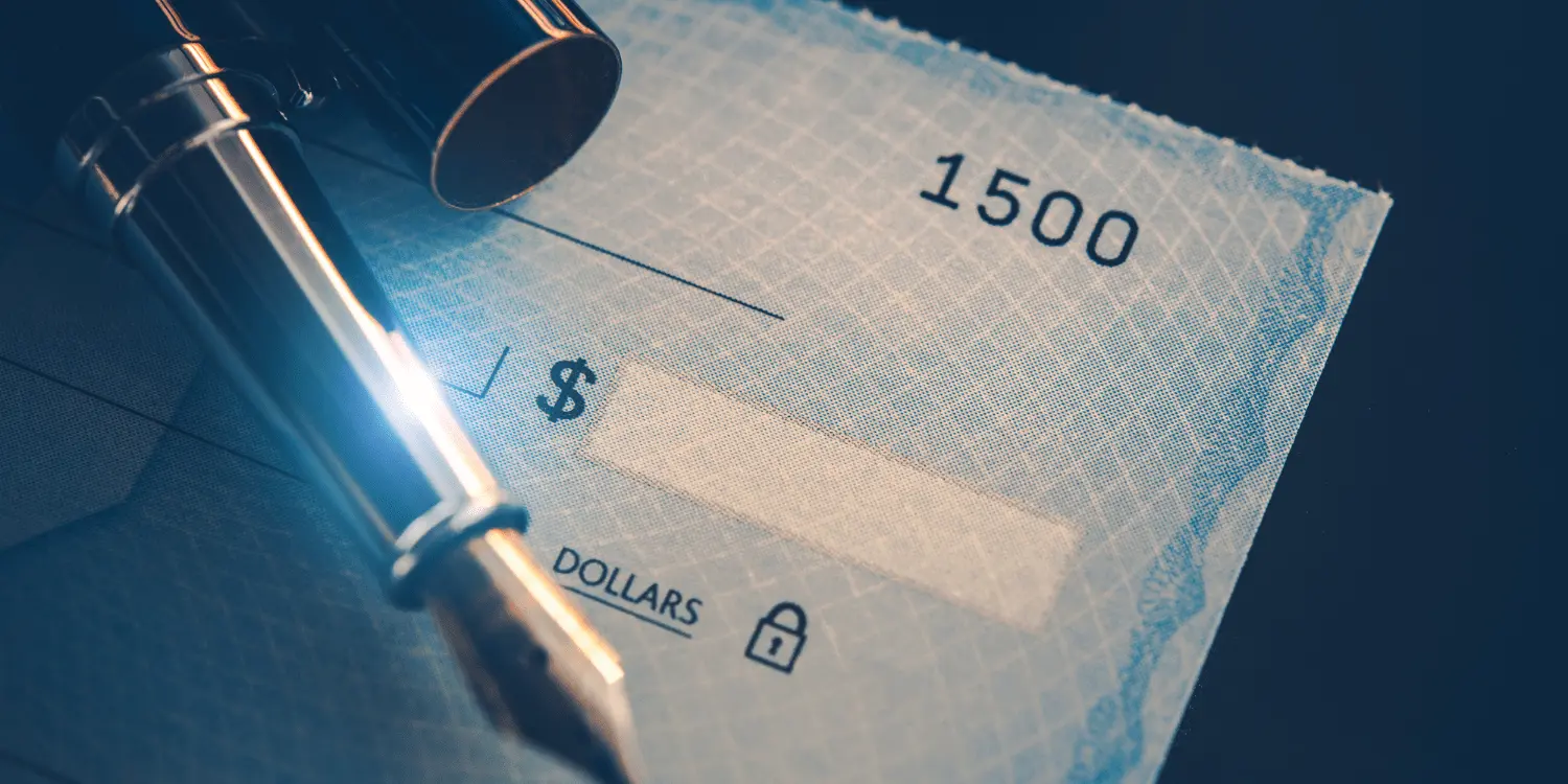 A blank presonal check with a fountain pen ready to fill in the check. 