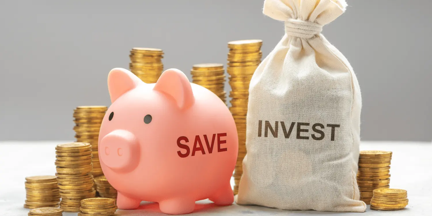 A savings pig with "save" written on it and a sack of money with "invest" written on it while having piles of coins behind the savings pig and investment money sack.