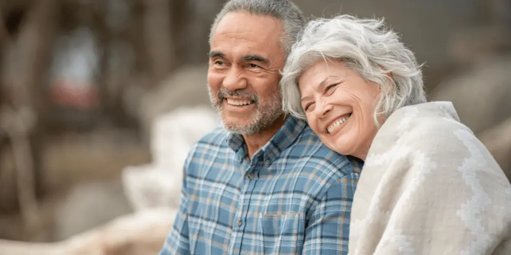 An joyful older couple smiling together, illustrating the advantages of reverse mortgages for retirement stability.
