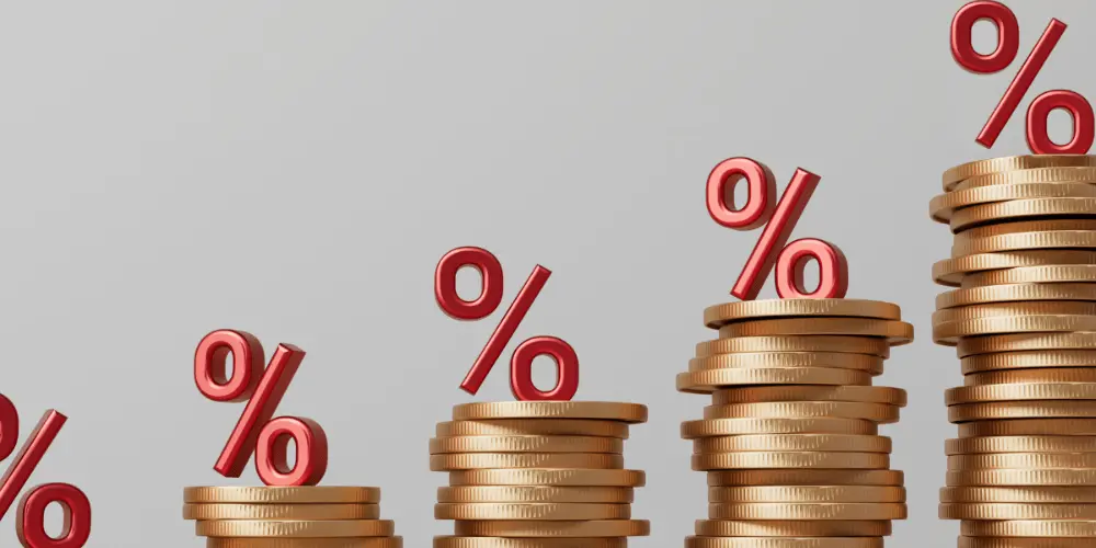 Coins stacked with a percentage sign above, representing the impact of credit card interest rates.