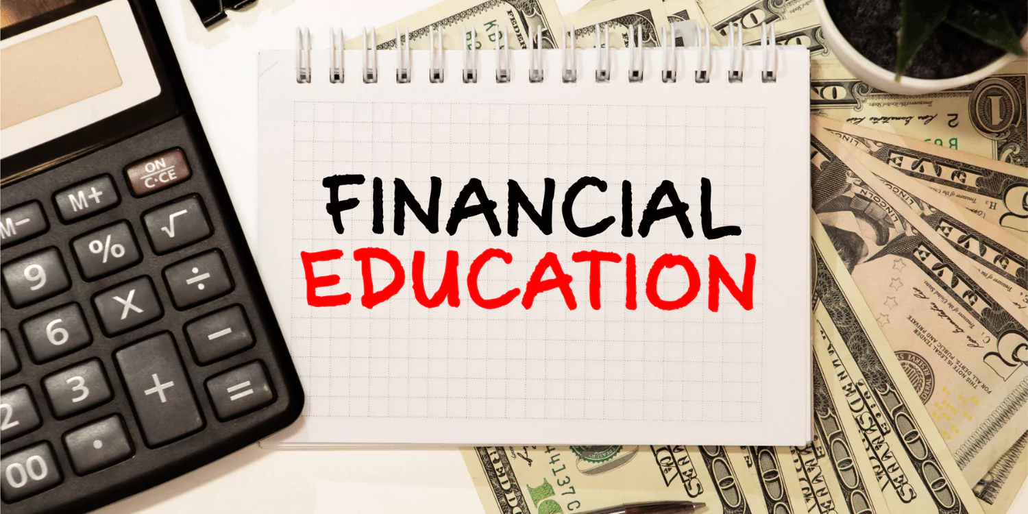 A calculator, dollar bills, and a notepad with the words 'Financial Education' written on it, symbolizing the importance of financial literacy and education.