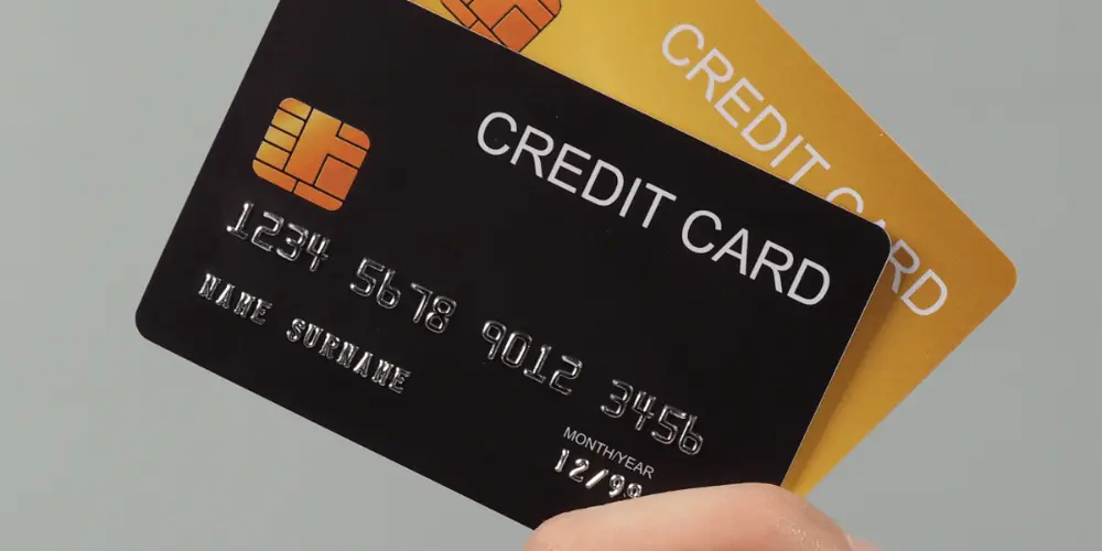 Ilustración de una tarjeta de crédito y un escudo con un cheque para el uso de una tarjeta de crédito asegurada para crear un historial crediticio y de pagos.