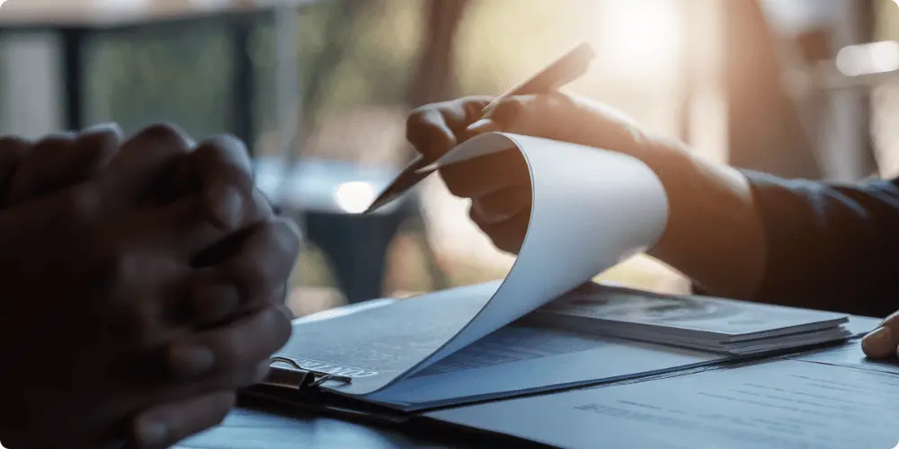 A person flipping through pages of various home loan options that are available to her from a guide given by Credit.org.