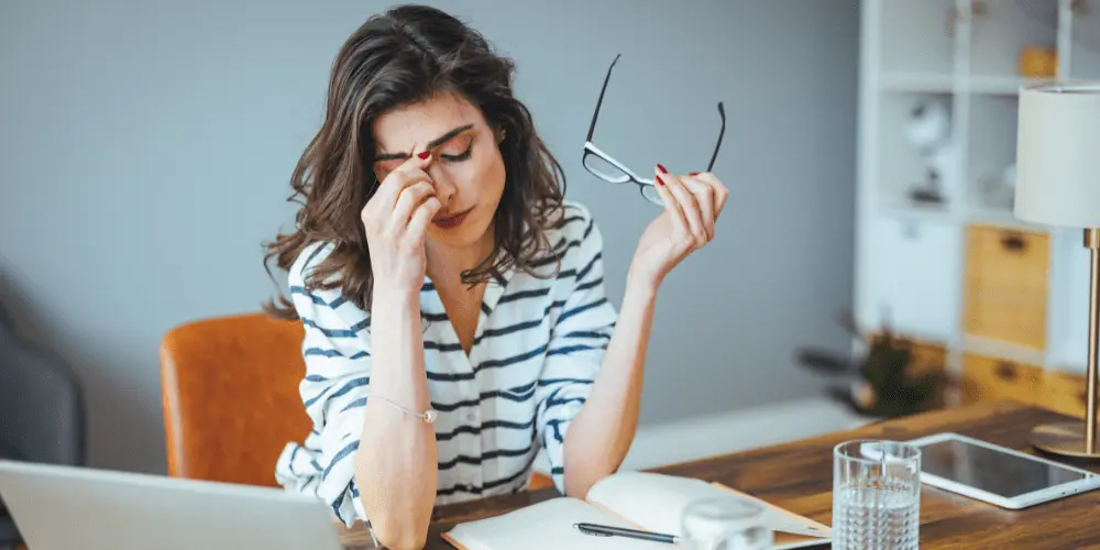 Worried renter at home looking over bills, showing the stress of falling behind on monthly rent payments.