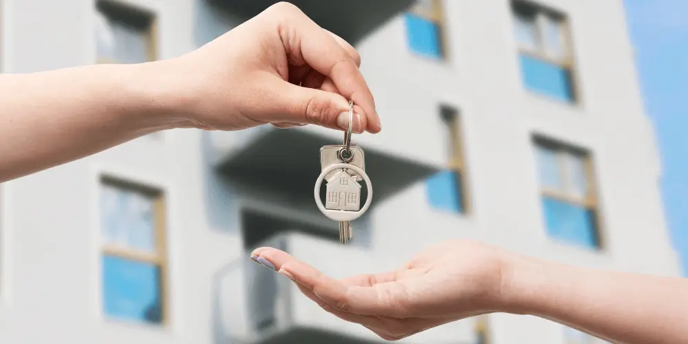 New tenant receiving apartment keys, highlighting the challenge of securing affordable rent in expensive cities.