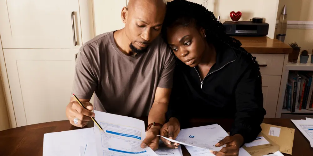 Stressed renters reviewing household expenses, focusing on paying rent during financial hardship.