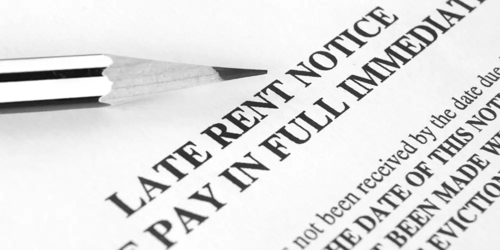 Close-up of a late rent notice, highlighting the challenge of catching up on rent while managing debt.