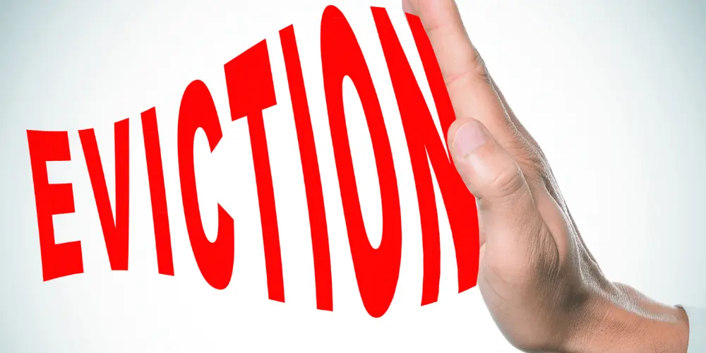 Hand stopping the word eviction, symbolizing legal and financial options to prevent losing housing.