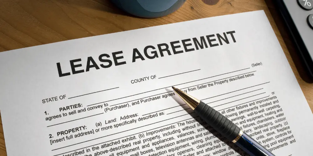 Close-up of a lease agreement document with pen, showing key terms first-time renters need to understand.