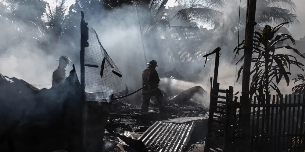Firefighters responding to a home fire, highlighting the importance of disaster recovery plans for protecting families and property.