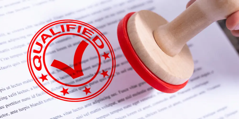 Red “Qualified” stamp on a document symbolizing FEMA relief eligibility approval after a disaster.