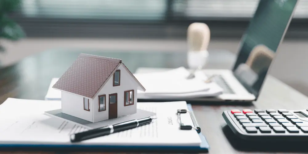 Mini house model, calculator, and documents showing how property taxes and escrow payments work.