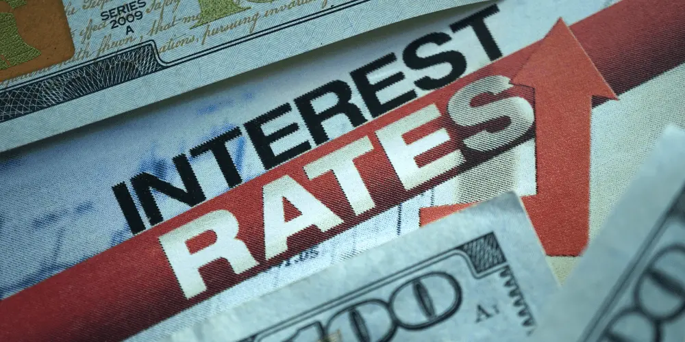 Close-up of the words interest rates with money, showing rising mortgage costs in a high-rate market.