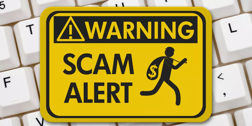 Yellow warning sign showing a scam alert, reminding student loan borrowers to watch for red flags and protect their personal information.
