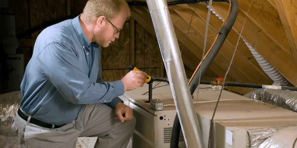 Home inspector checking attic systems for issues that could be costly repairs and important to negotiate before buying a house.
