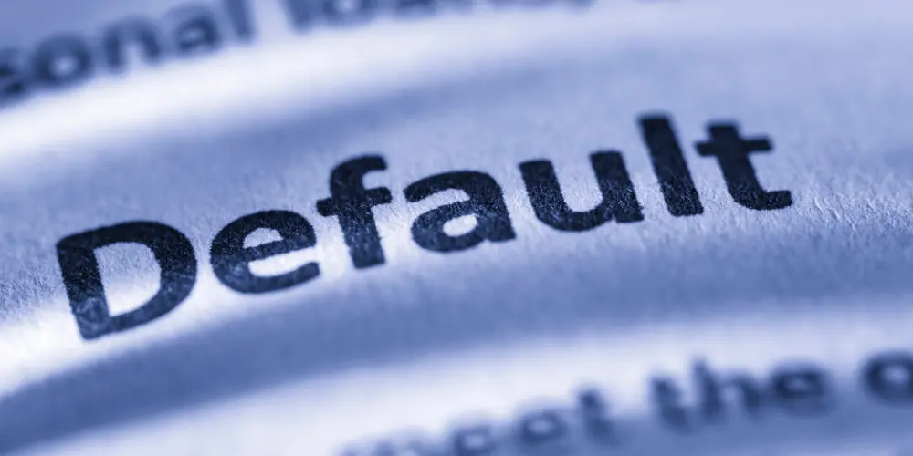Close-up of the word ‘default,’ highlighting the risks and triggers of mortgage default for both forward and reverse loans.