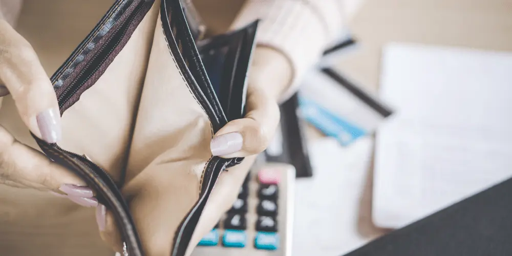 Empty wallet and bills on a desk, showing financial hardship and the need to explain payment struggles to creditors.
