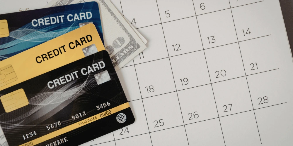 Credit cards on a calendar, representing missed payments and the real consequences of stopping credit card debt payments.