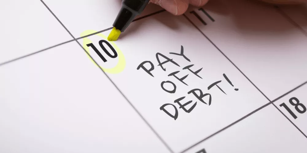 El calendario marcado como "Saldar deudas" el día 10 muestra cómo un planificador de pago de deudas ayuda a programar y realizar un seguimiento de los pagos de la deuda.
