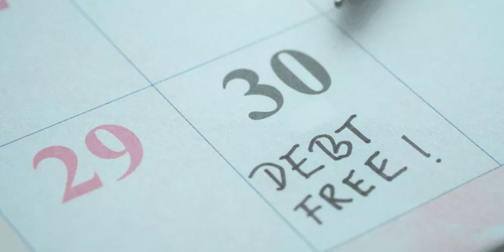 Calendar marked ‘Debt free’ on the 30th illustrating a debt payoff planner helping you reach a debt-free goal.