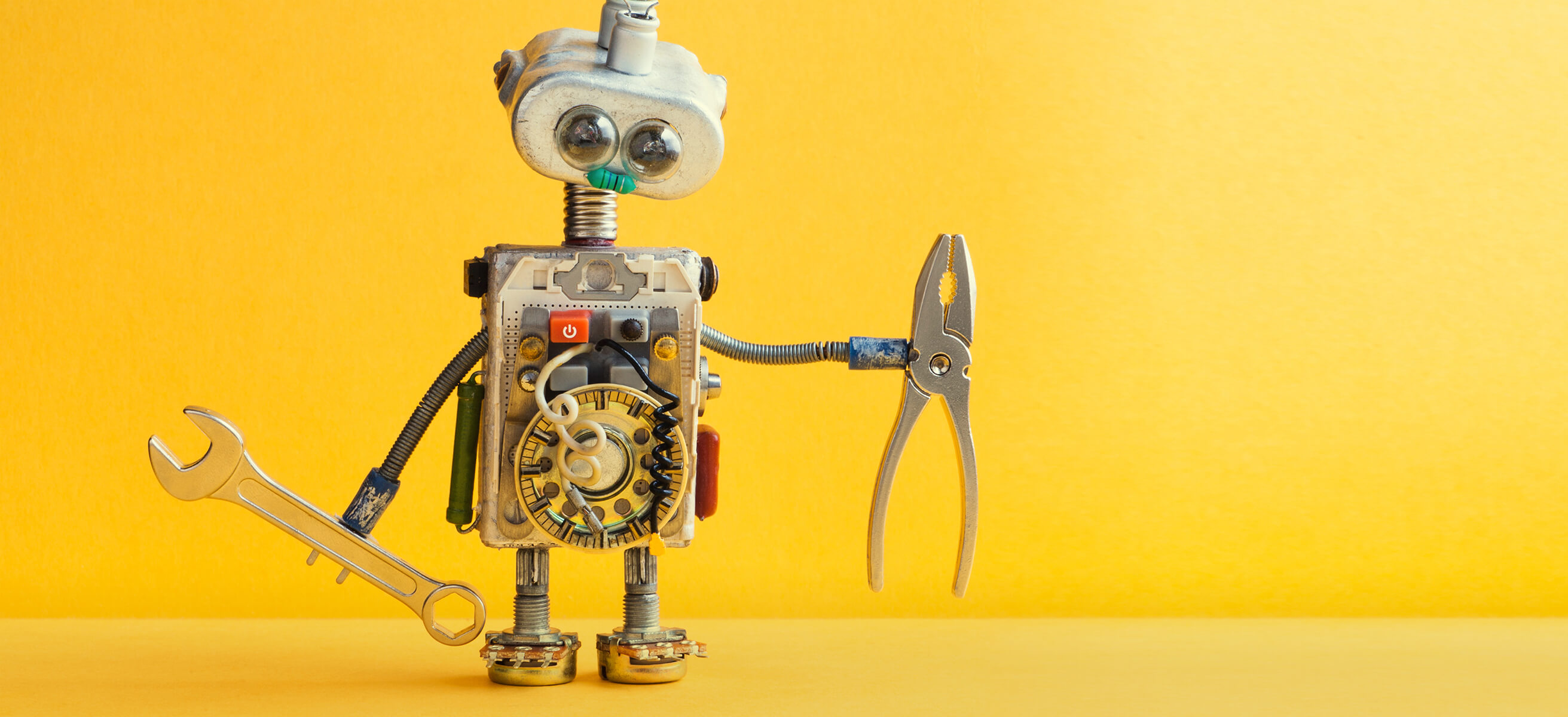 Ein süßer Retro-Roboter hält eine Zange und einen Schraubenschlüssel in den Händen