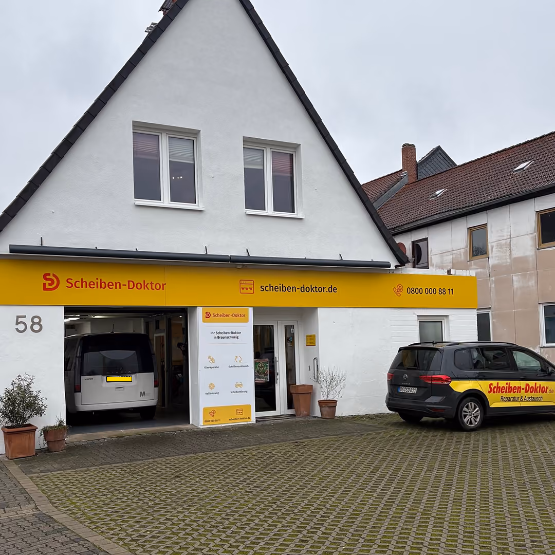 Scheiben-Doktor-Werkstatt im weißen Giebelhaus Nr. 58 mit Firmenwagen