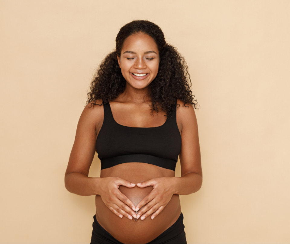 Pregnant woman smiling and stroking her belly