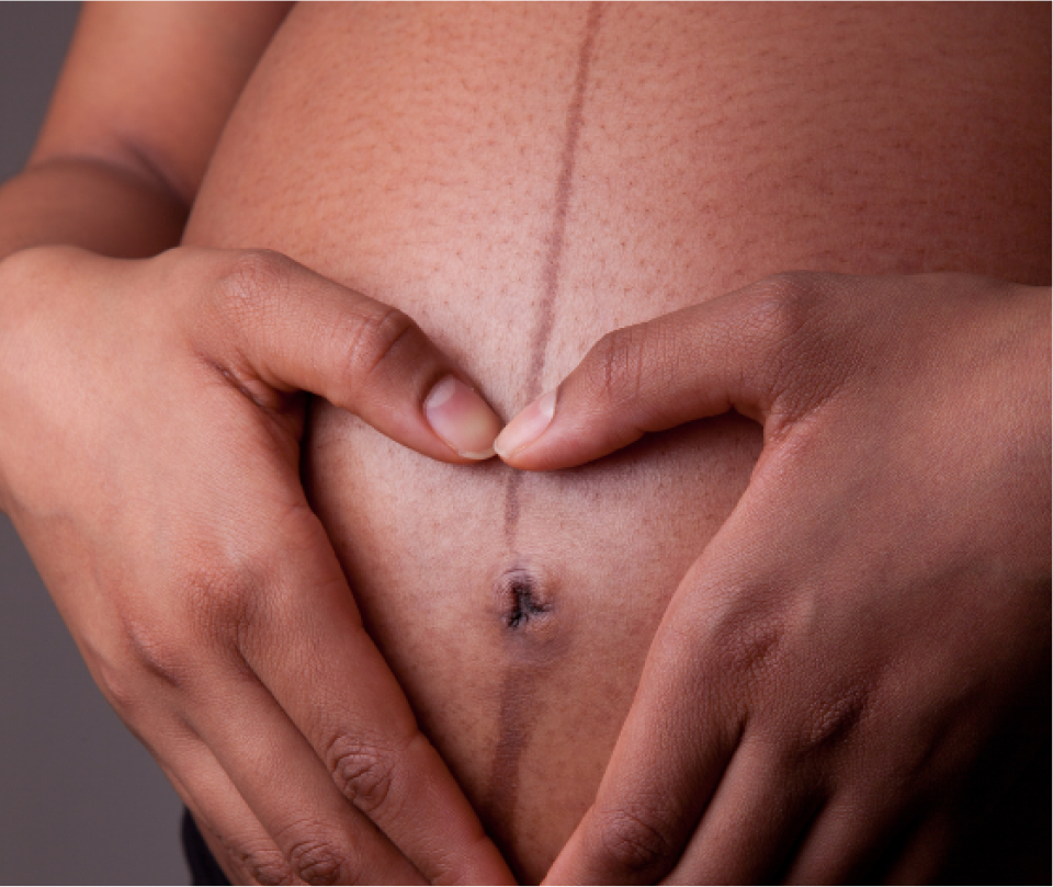 Pregnant woman smiling and stroking her belly
