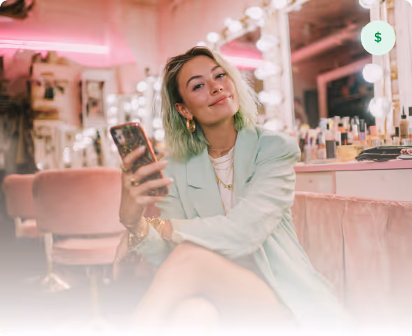 Barber wearing green gloves grooming a man’s high-top haircut with blue-dyed tips.