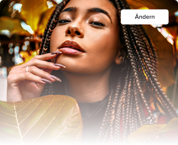 Close-up of a woman with braided hair gently touching her face, surrounded by autumn leaves.