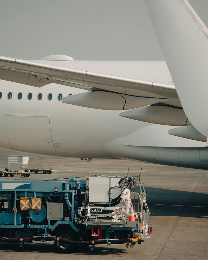 Plane with refuelling vehicle alongside it.