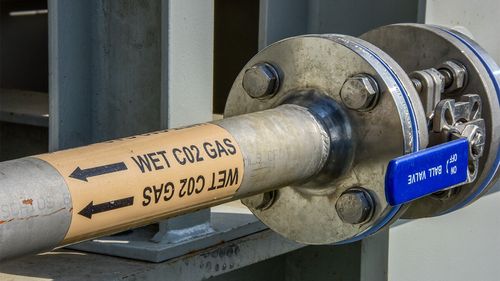 Industrial pipe that reads 'wet CO2 gas'.
