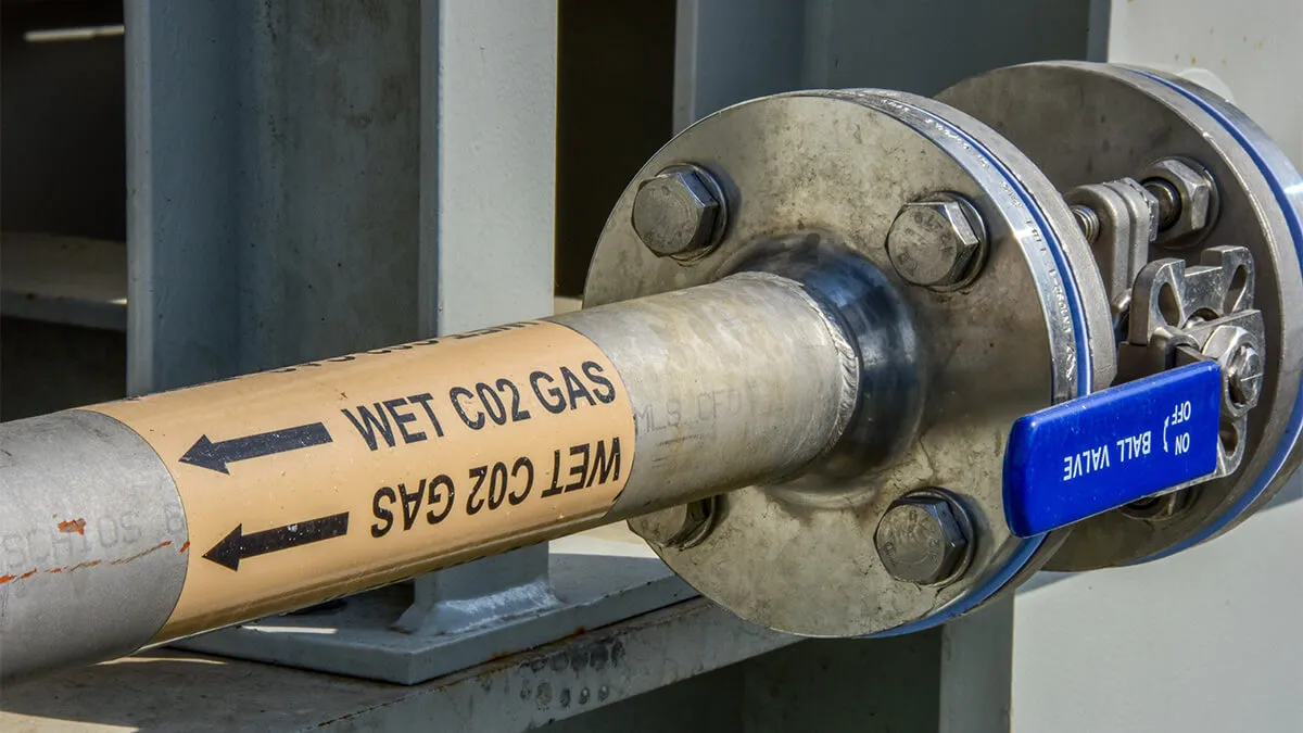 Industrial pipe that reads 'wet CO2 gas'.