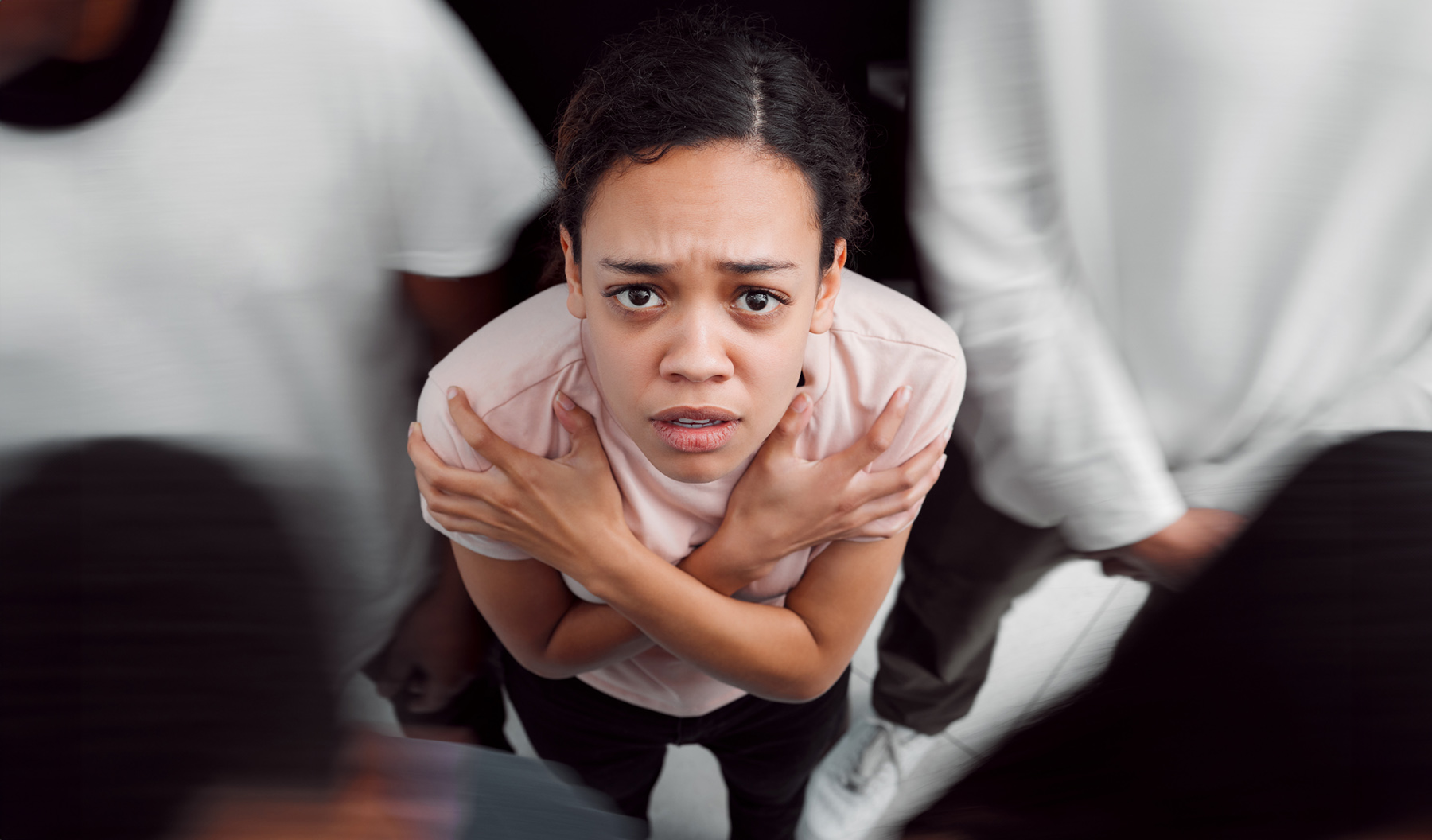 Worried woman surrounded by blurred figures, representing the isolation of unspoken needs
