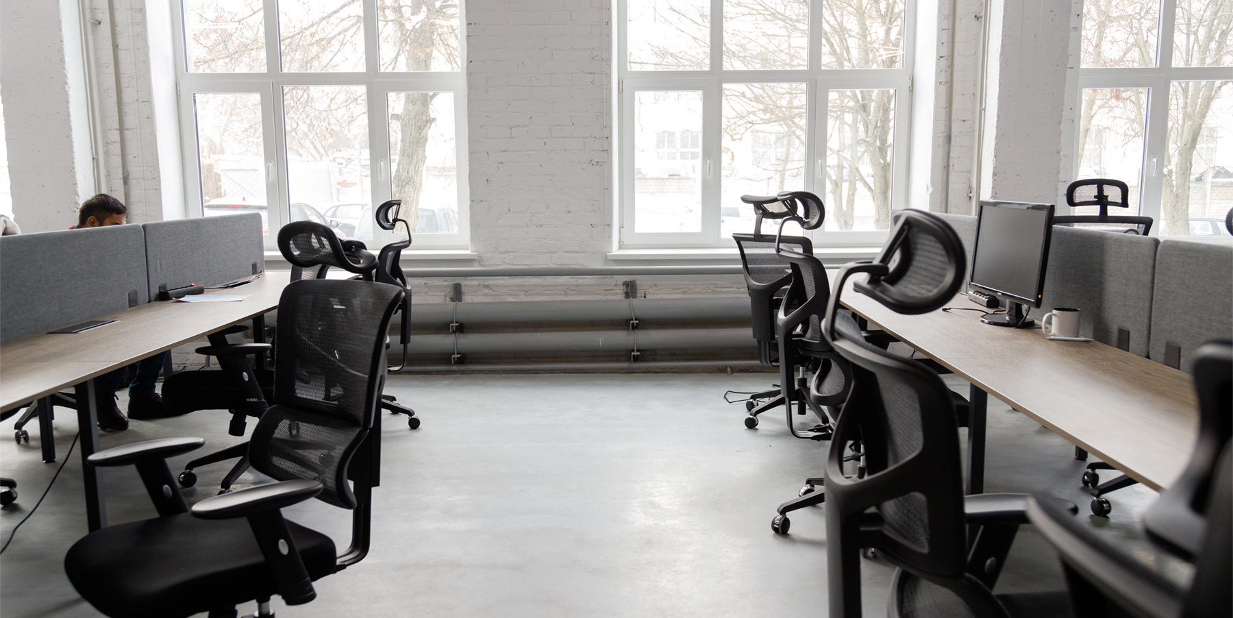 Bright modern office space with empty workstations, representing the absenteeism and turnover cost of unaddressed mental health