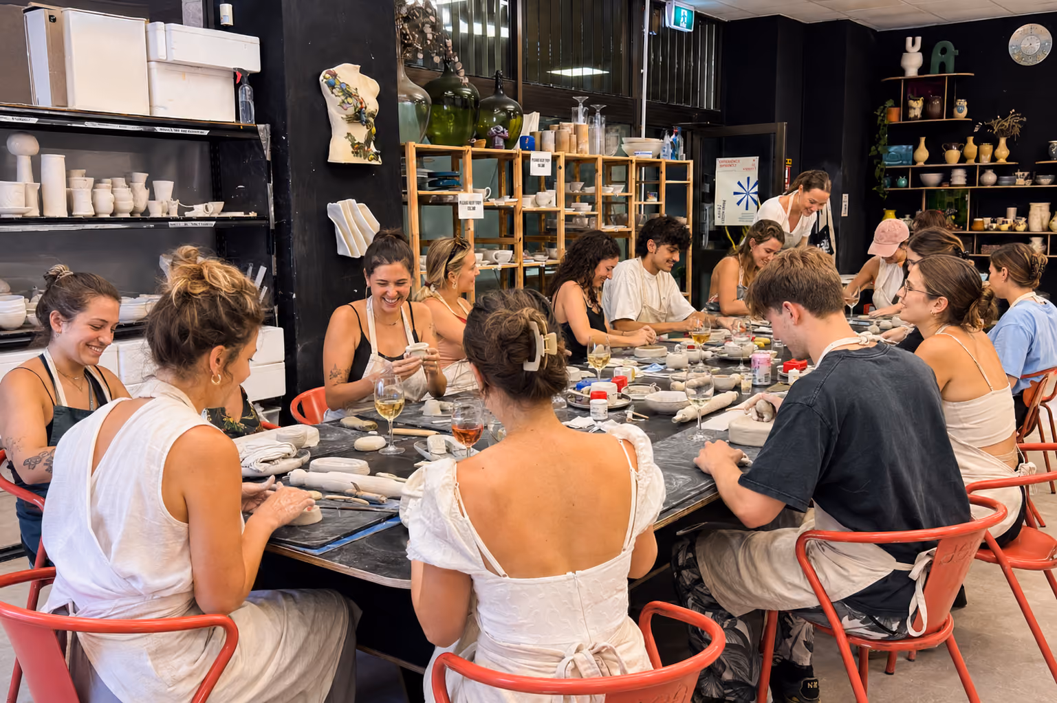 Hands shaping clay on the pottery wheel at The Art Department studio