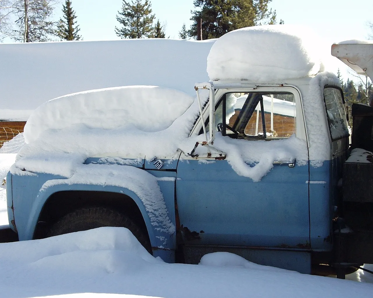 Snow-covered Ford F-500 parked outside, awaiting winter vehicle service at a heavy-duty repair facility.