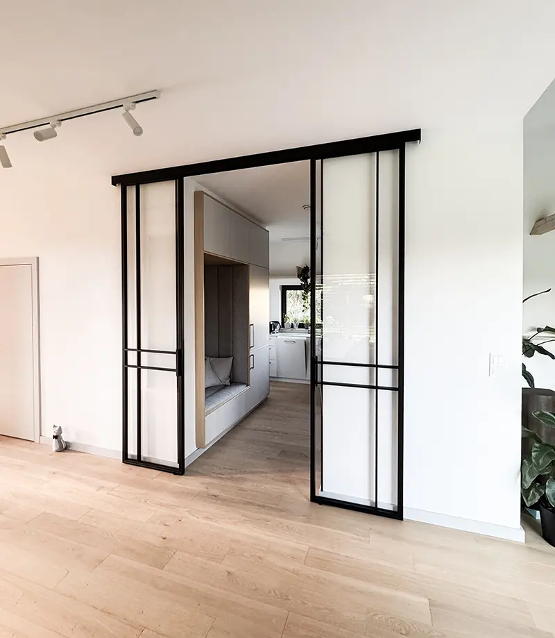 Drzwi przesuwne loftowe między salonem i kuchnia, na wymiar w kolorze czarnym w stylu industrialnym z wypełnieniem ze szkła bezpiecznego
