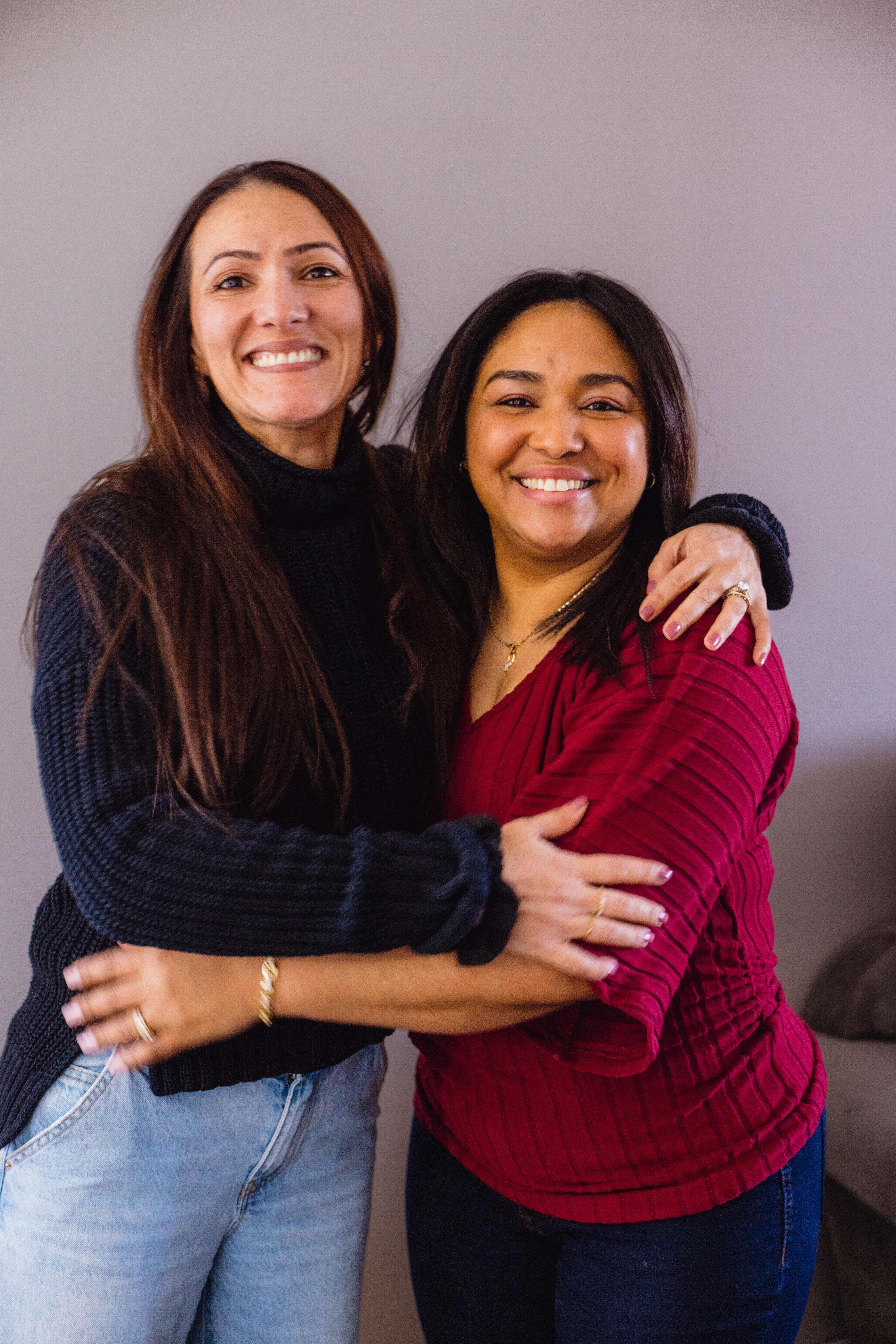 Two international teachers smiling and hugging
