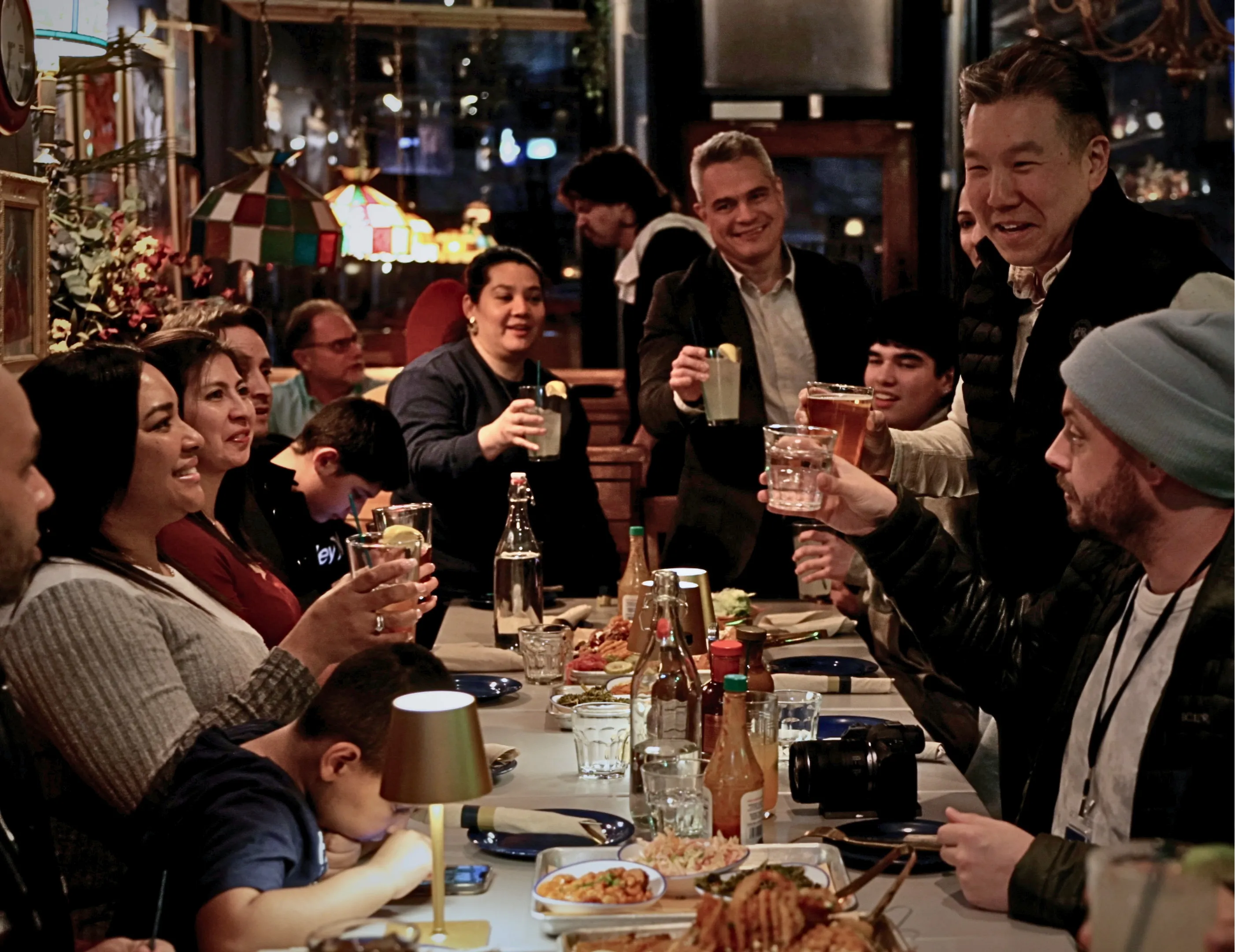 Teachers and the Intrax team raising a toast around a long table at a Chicago restaurant