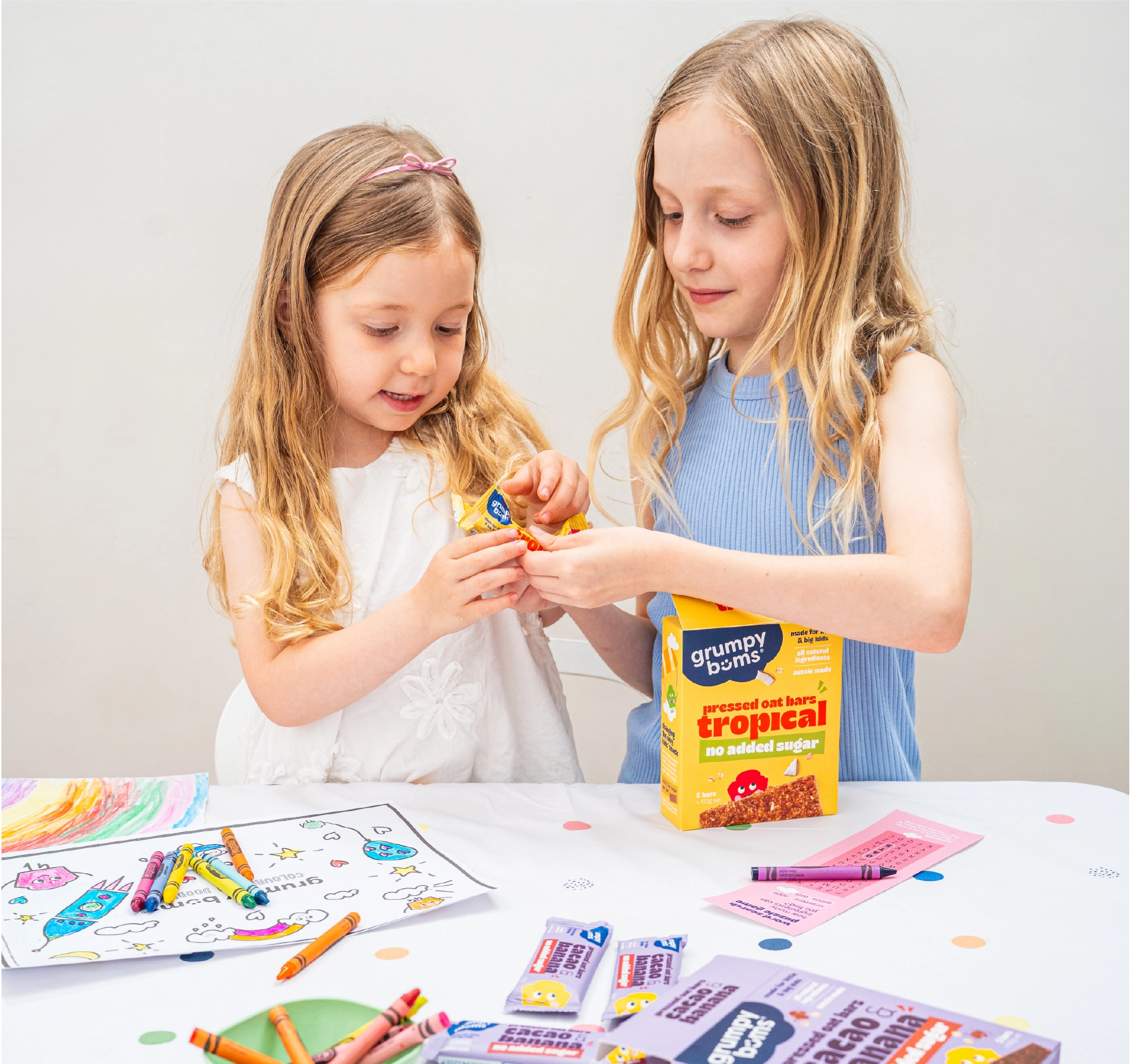WeAreDepot Packaging Design, two young girls enjoying Grumpy Bums pressed oat bars on a white background, Australian kids healthy snack brand
