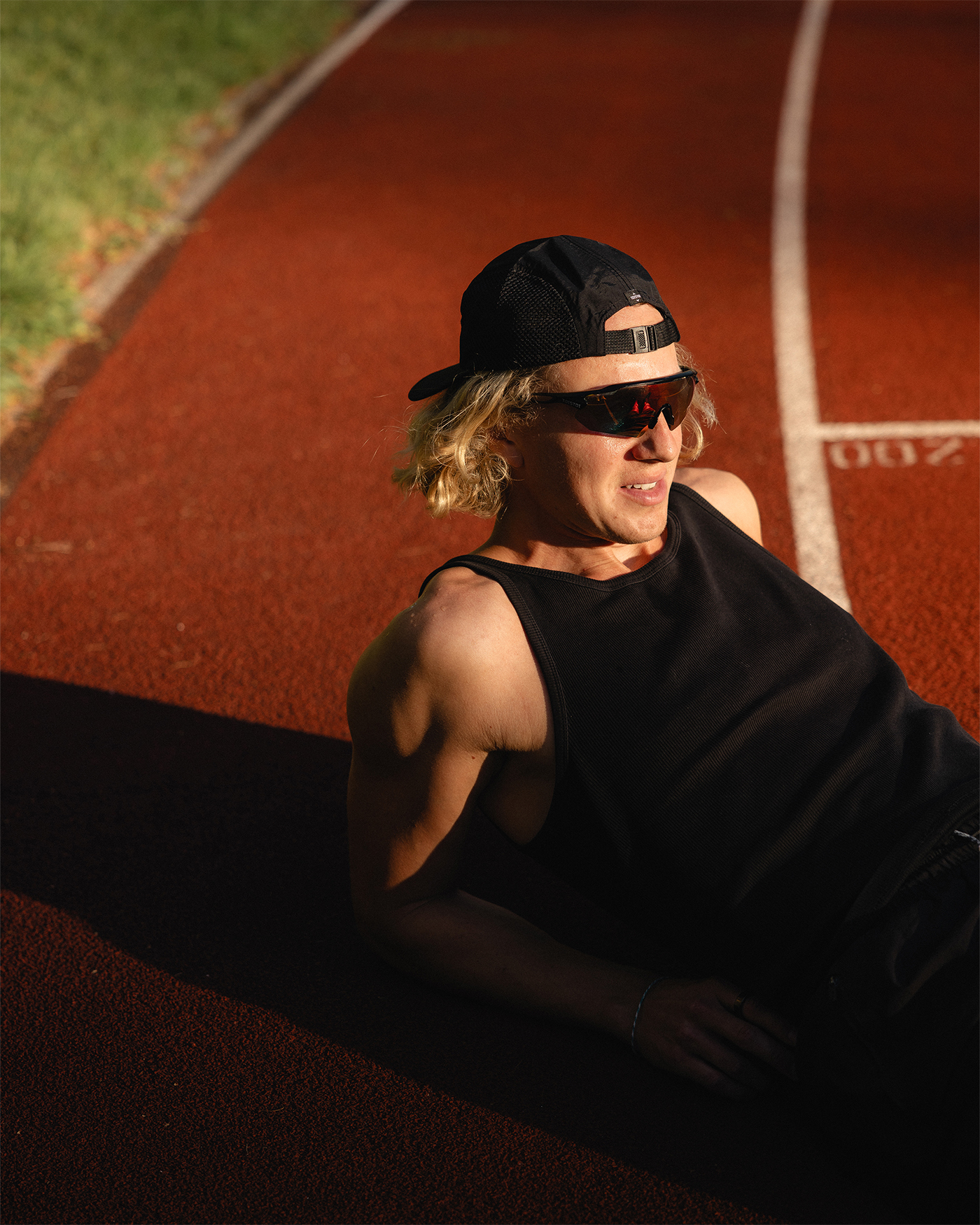 Urheilija venyttelee juoksuradalla