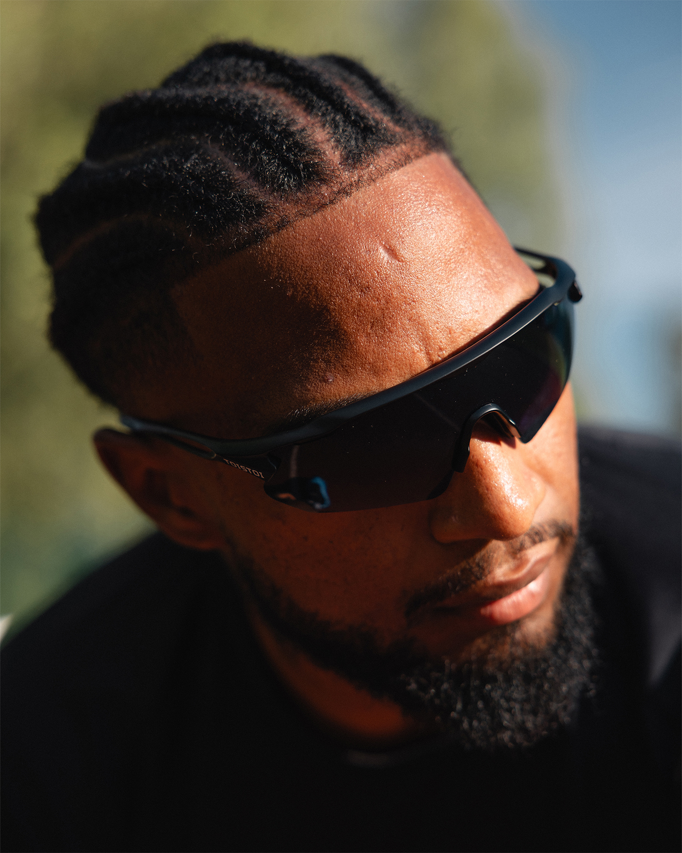 Miesurheilija aurinkolasit päässä