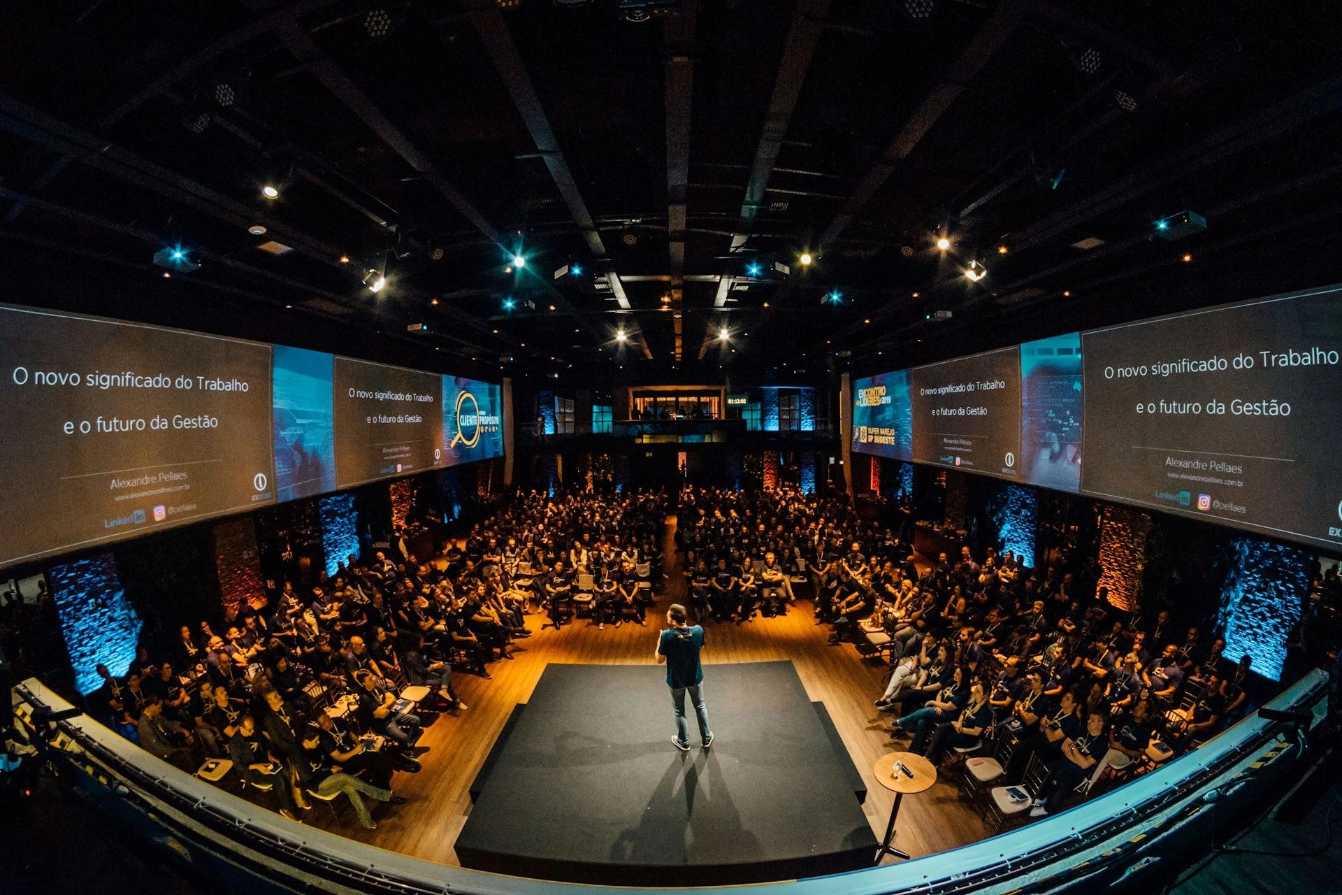 Speaker presenting to a large audience at an international leadership conference.