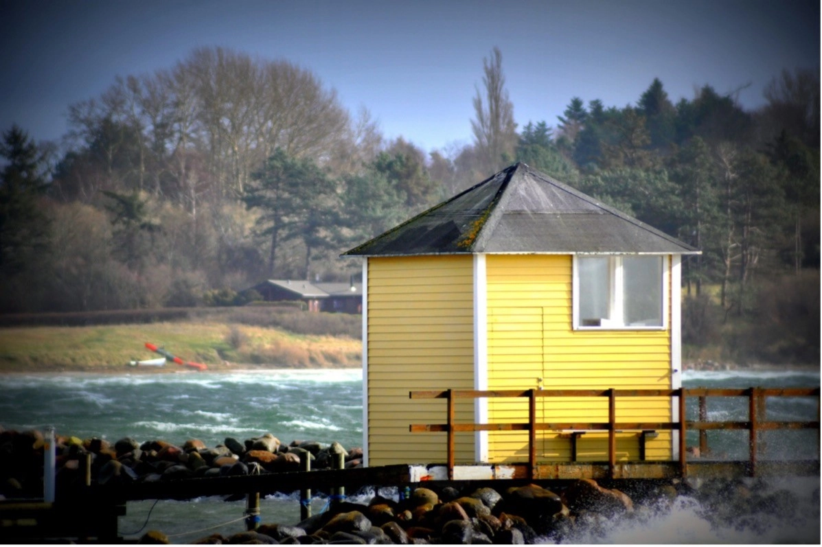 Yellow coastal building by the sea in Halsnæs Municipality, Denmark.
