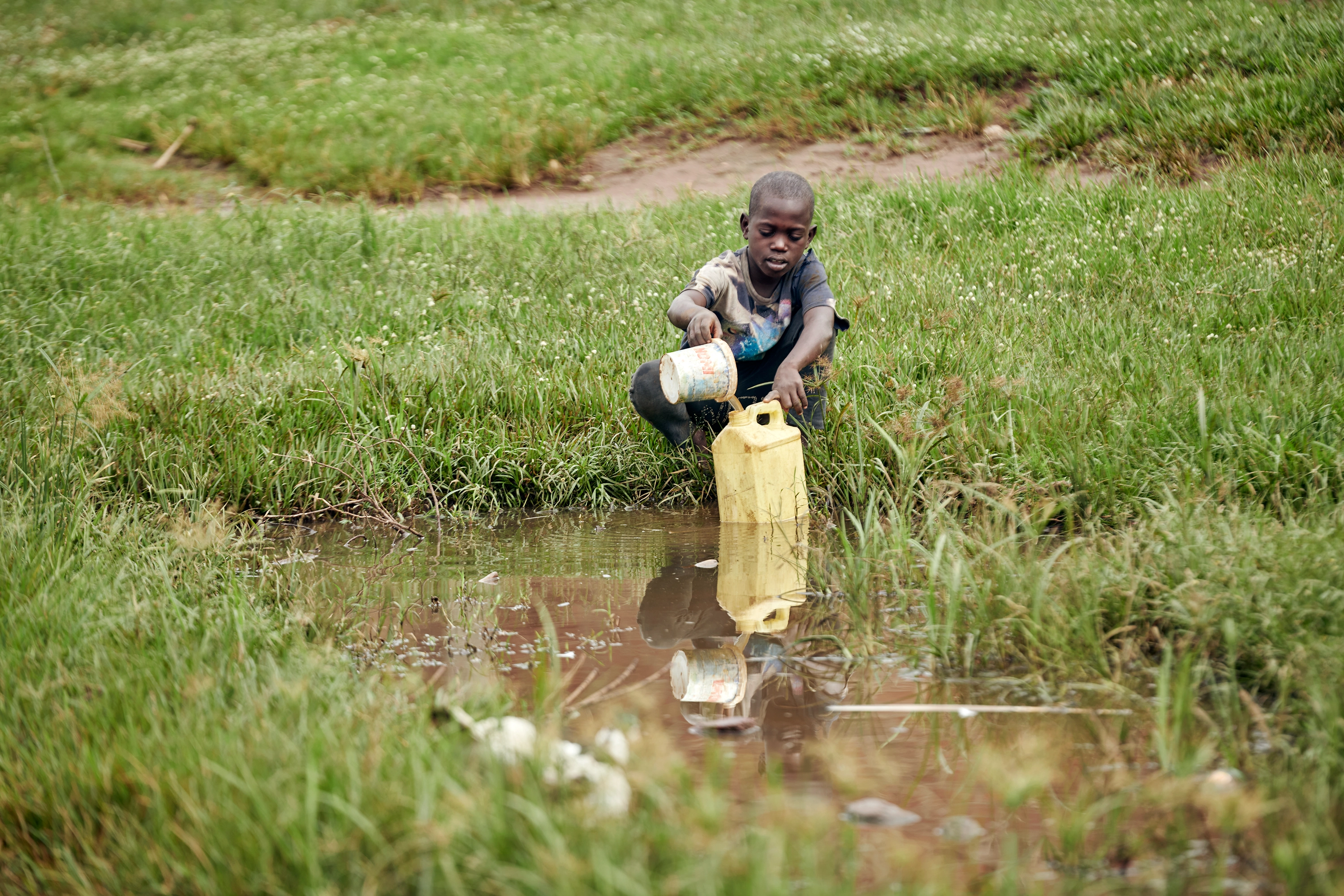 Child collecting water in a rural area, illustrating the importance of access to safe water.