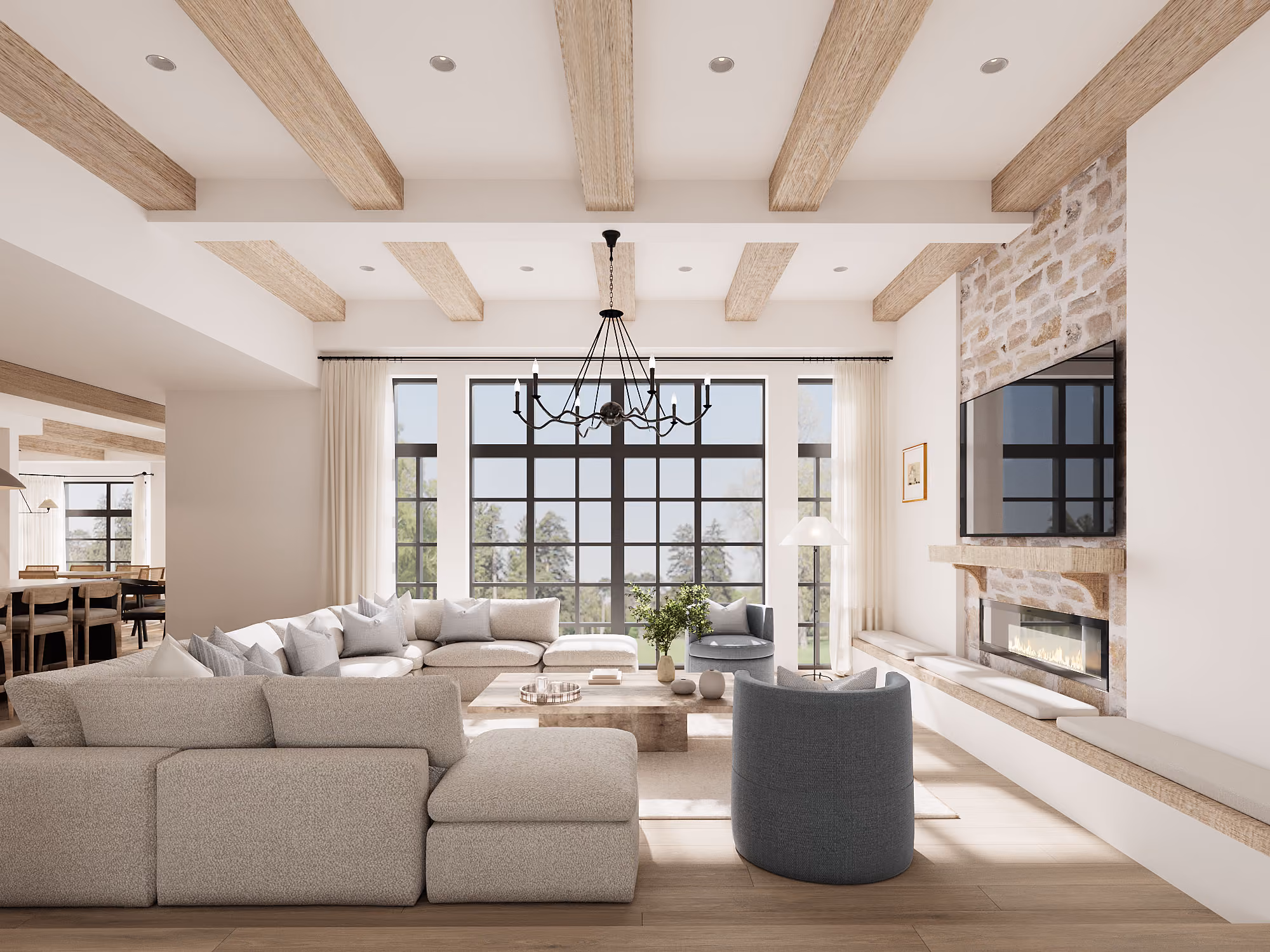 Spacious living room with beige sofas, stone fireplace, large windows, wooden beams, and chandelier.