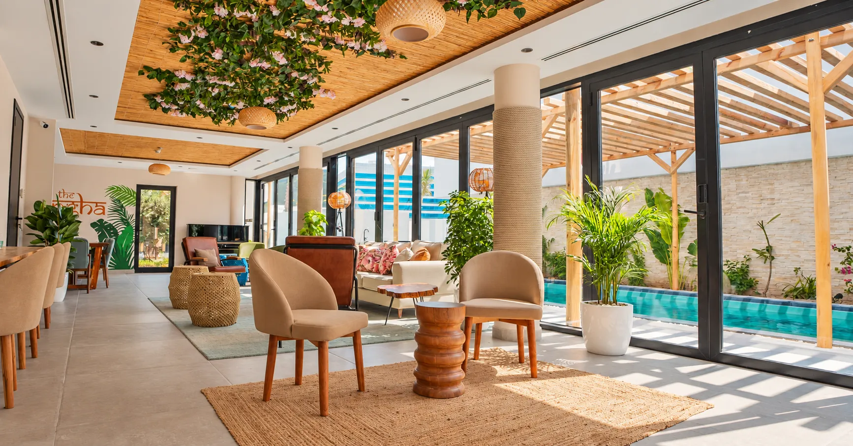 The living room of a Nas House villa opening onto the pool